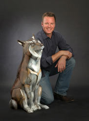 Josh Tobey with his bronze wolf sculpture